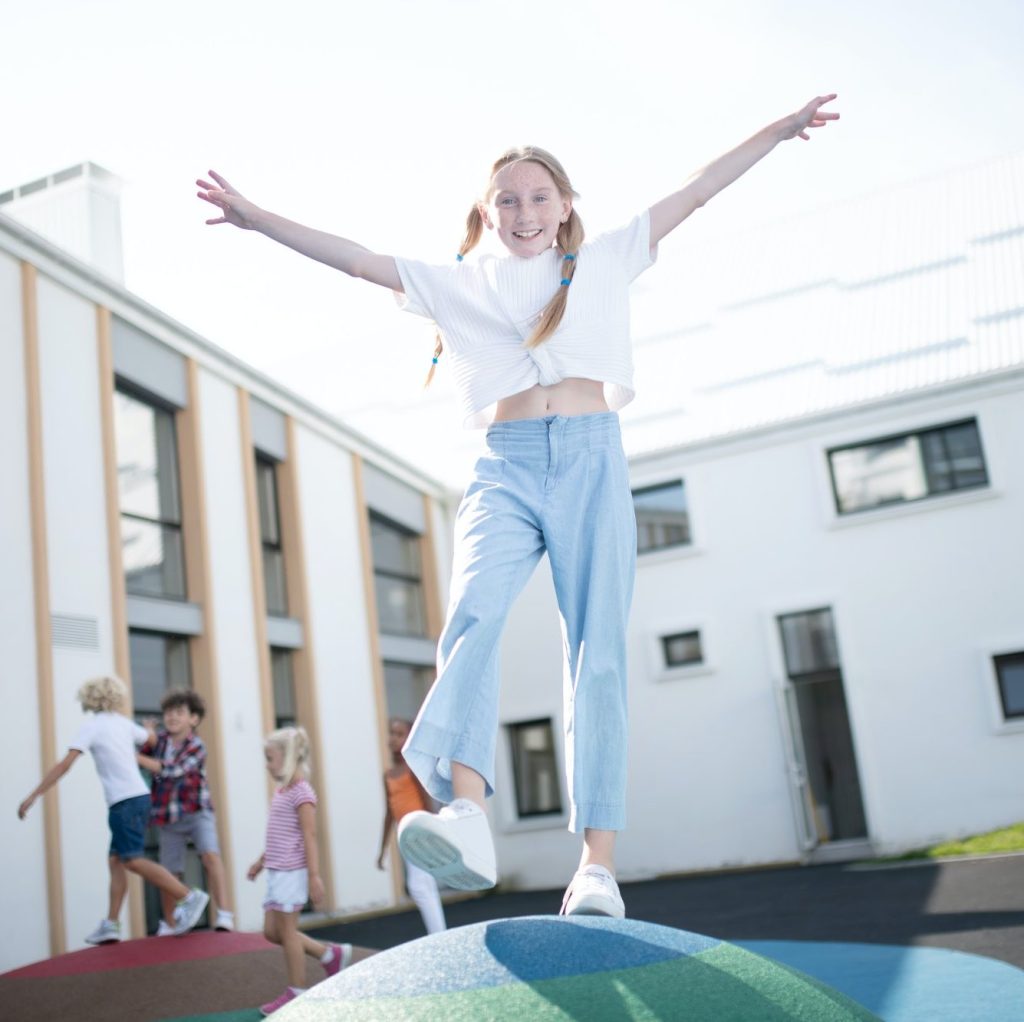 Cheerful schoolgirl playing outside on school break