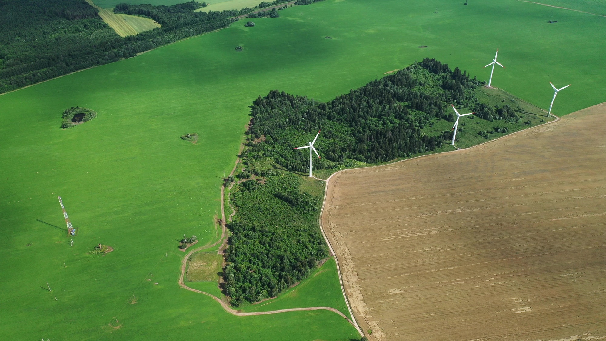 Windmills in summer in a green field.large windmills standing in a field near the forest.Europe