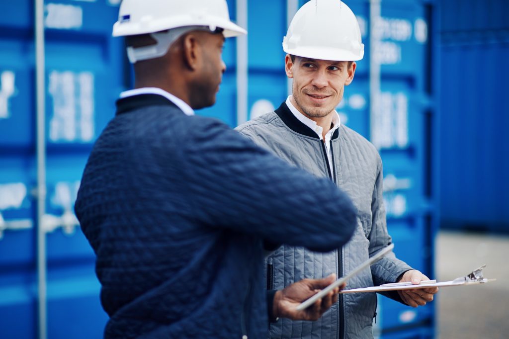 Freight manager talking with an engineer in a shipping yard