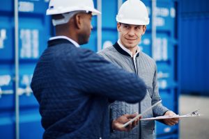 Freight manager talking with an engineer in a shipping yard